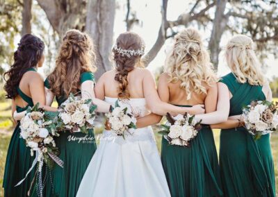 Portrait of bride with bridesmaids from behind. Image by Umphie Photos.