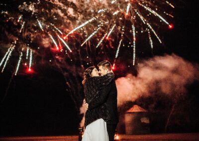 The C Bar silo glows in the background as fireworks illuminate the sky during this couple's exit. Image by 28 North Photography, www.28North.co.