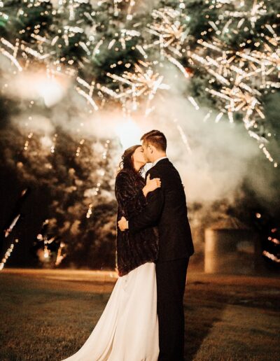 This bride and groom exited their reception to a sky lit with fireworks. The bride wore a fur coat in the chilly night air. Image by 28 North Photography, www.28north.co.
