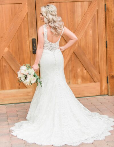 Bride in gown in front of barn doors
