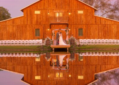 The barn front reflects into the pond, creating a mirror image and an unforgettable wedding portrait location. Image by thereflectionsstudio.com.
