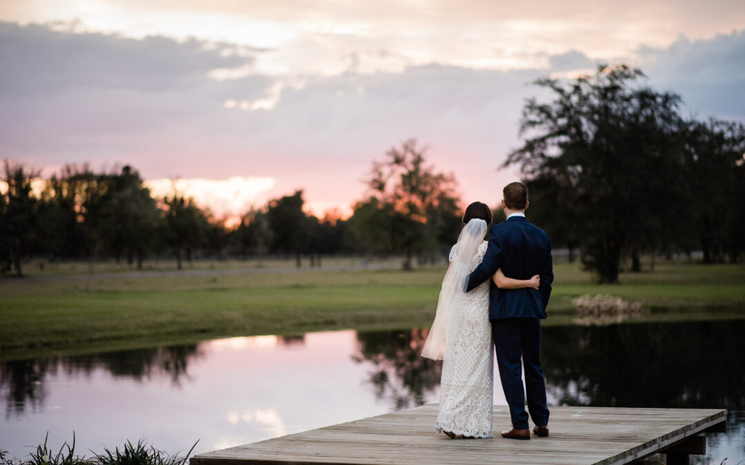 Couple faces the sunset on the dock by Amber Dorn Photography