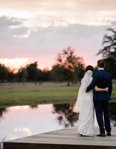 Couple faces the sunset on the dock by Amber Dorn Photography