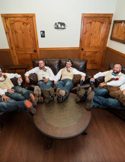 A groom and his groomsmen relax in the groom's suite on wedding day in the C Bar Ranch party barn. Photo by joshhaltam.com of St. Augustine, Florida.