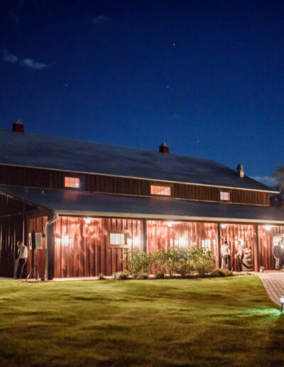 The C Bar Ranch party barn glows under starlight at night.