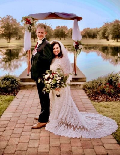 Bride and groom on the walkway to the ceremony site on the C Bar Ranch pond.