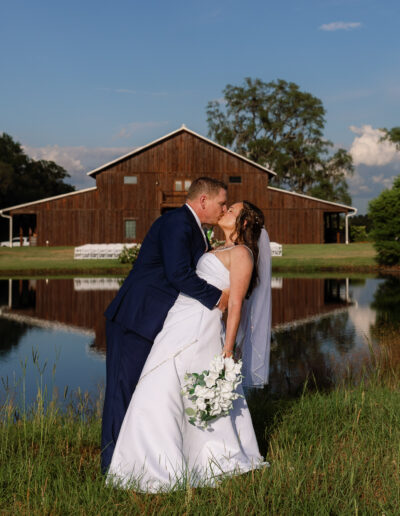 Bride and groom in front of the C Bar Ranch pond and party barn.