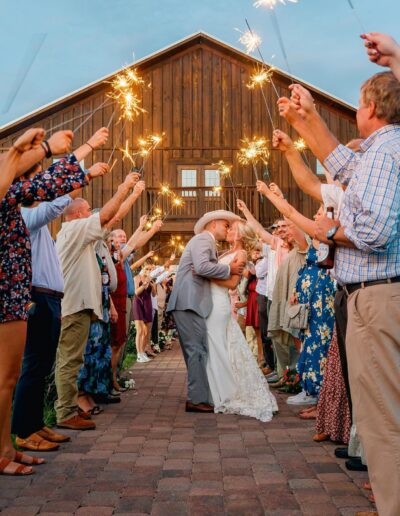 Bride and groom exit the party barn through sparklers at C Bar Ranch.