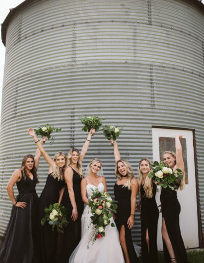 Bride and bridesmaids strike a pose with bouquets at C Bar Ranch silo.